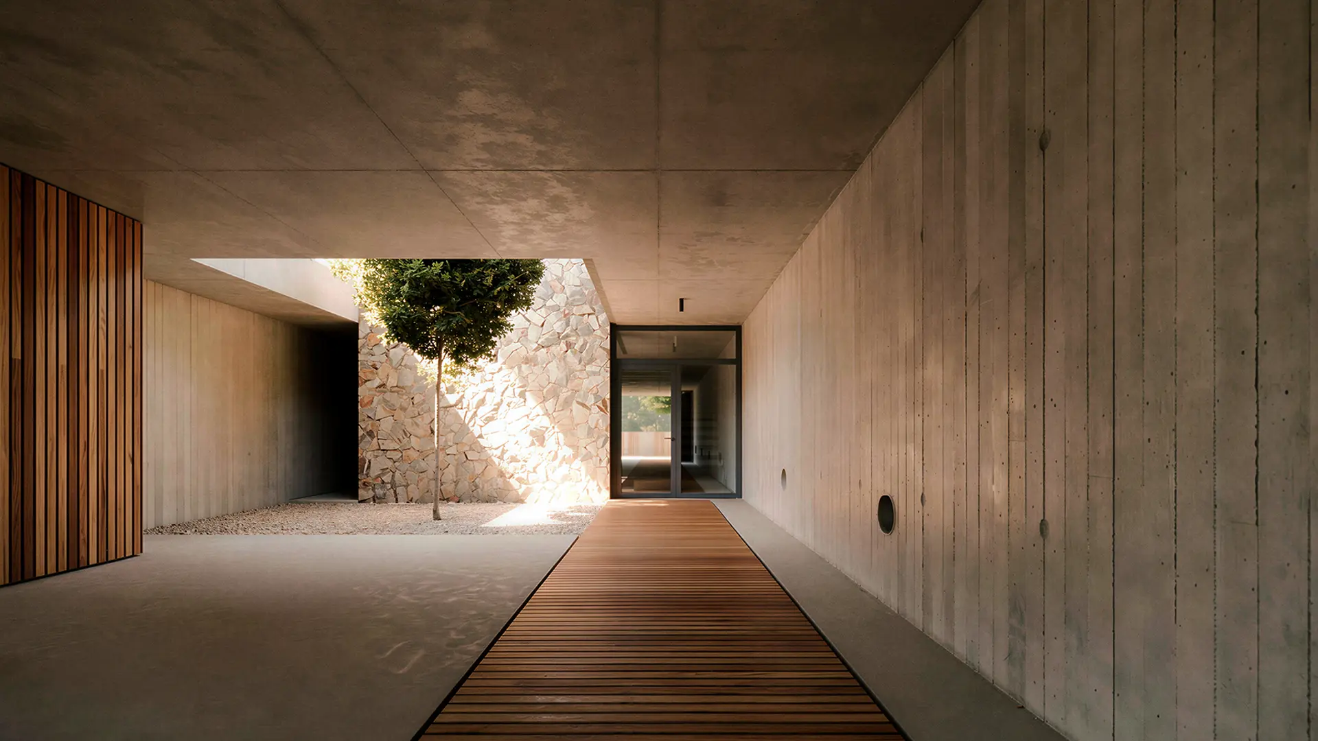Acceso de día a vivienda unifamiliar de obra nueva en Cardedeu, con pasarela de tarima de madera entre paredes de hormigón visto que enmarcan un patio interior con árbol y muro de mampostería de piedra natural. Propuesta de diseño de Tova Arquitectura